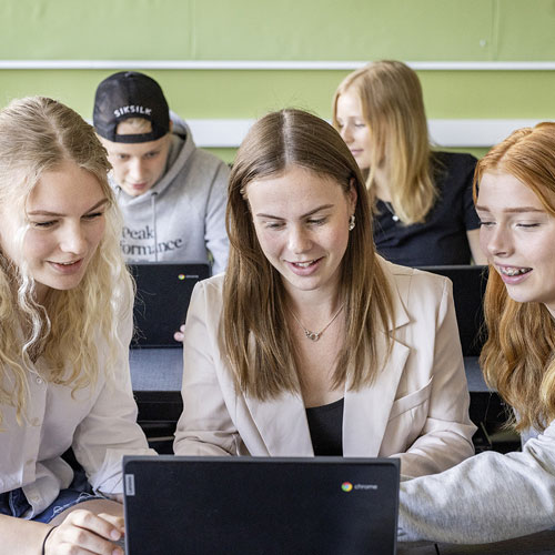 Tre elever samarbetar vid en laptop